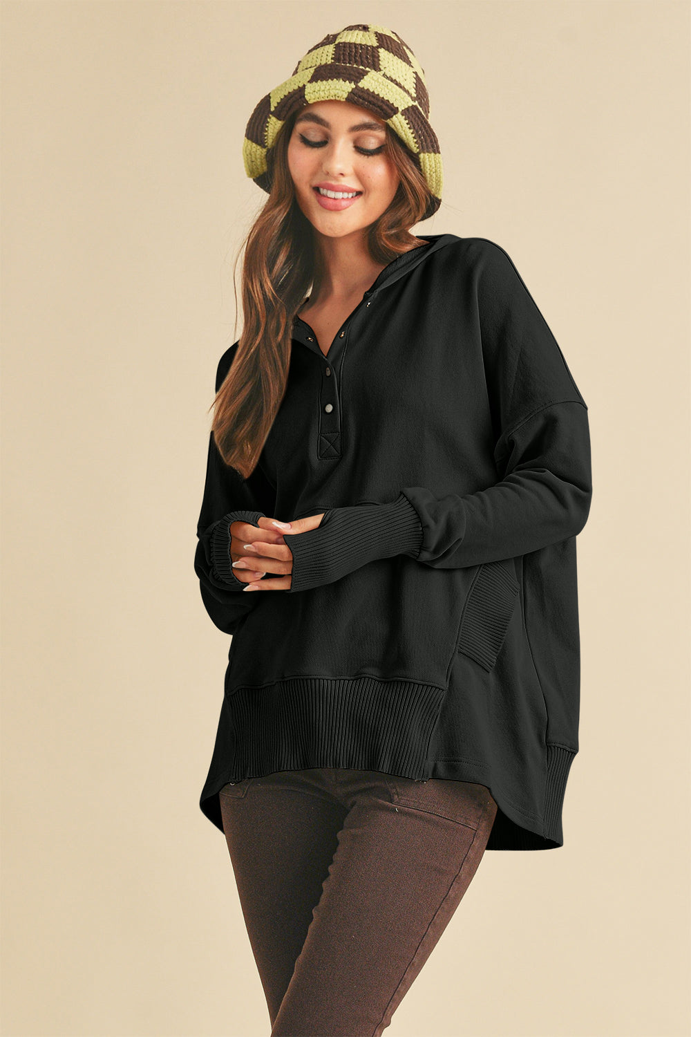 Noiré Whisper Snap Hoodie in black, styled with brown pants and checkered hat.