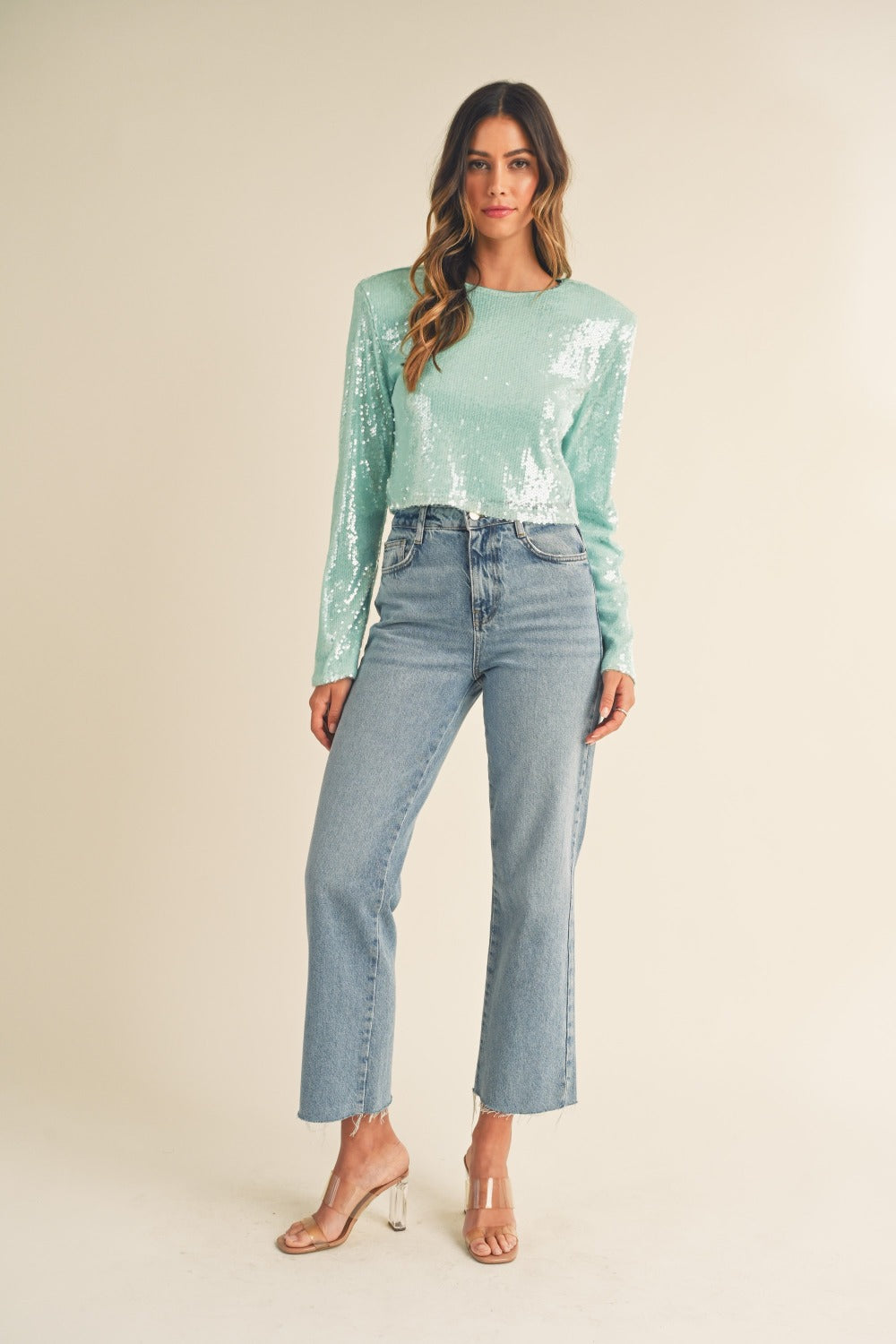 Full body view of green shoulder padded sequin crop top