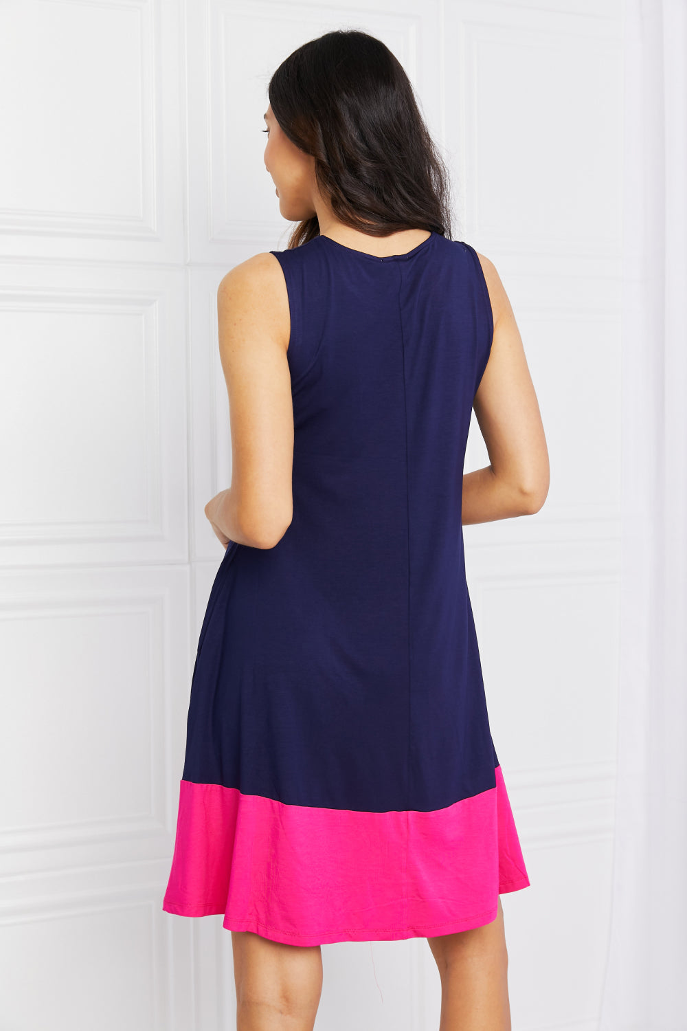 Back view of two-tone sleeveless mini dress with pockets.