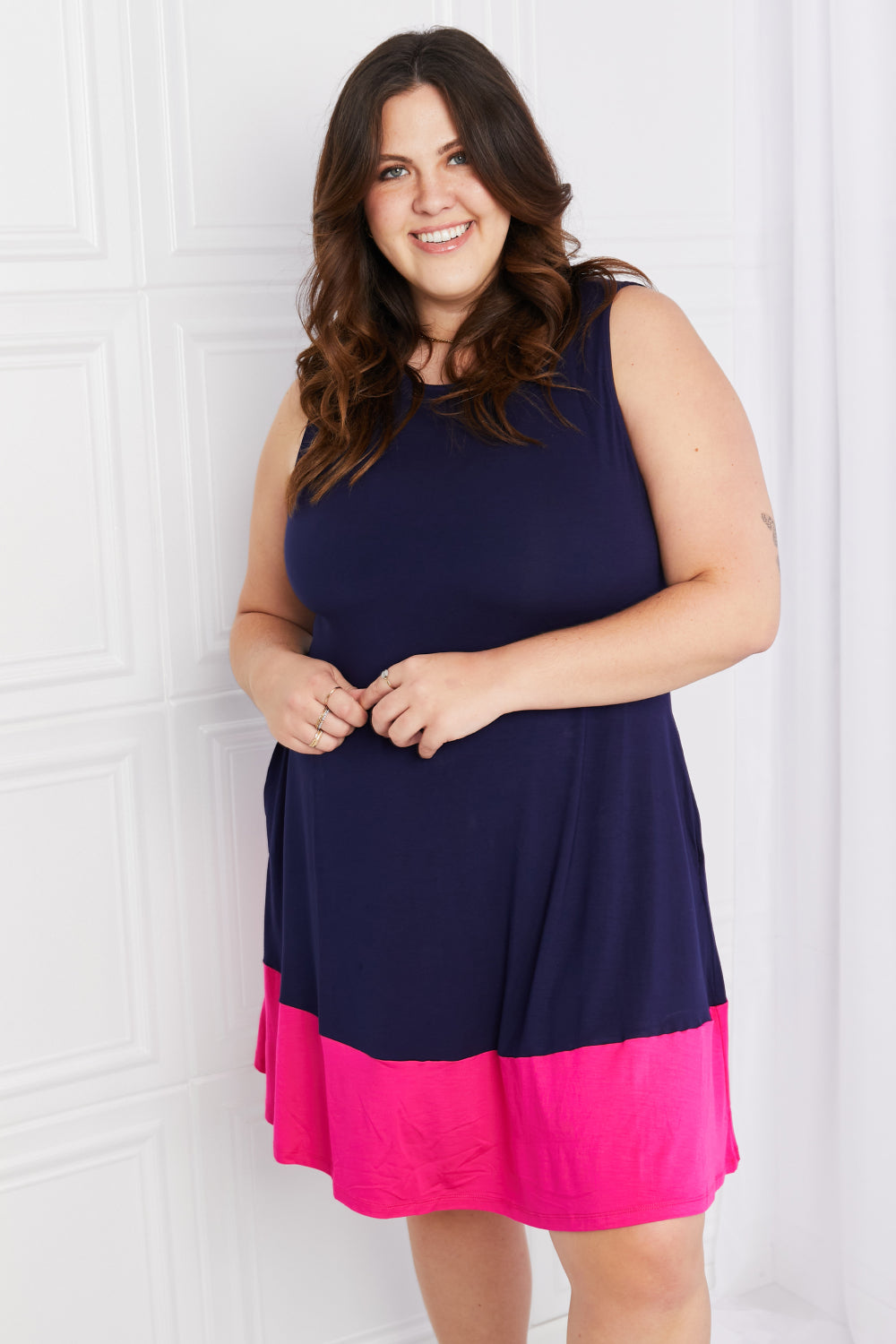 Plus-size model in two-tone sleeveless mini dress, front view.