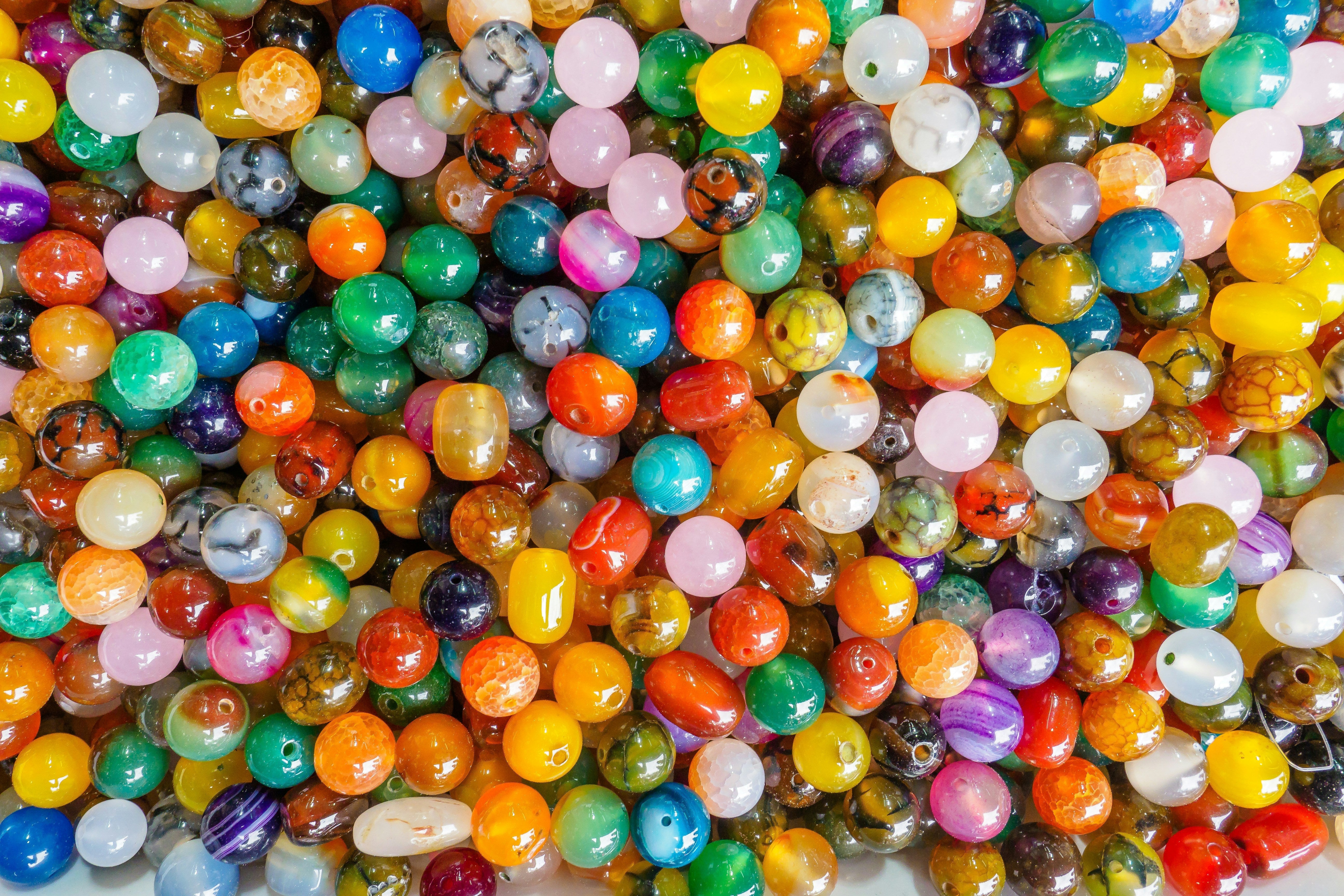 Colorful beads in a large pile, various shapes and sizes, perfect for crafting or jewelry making.