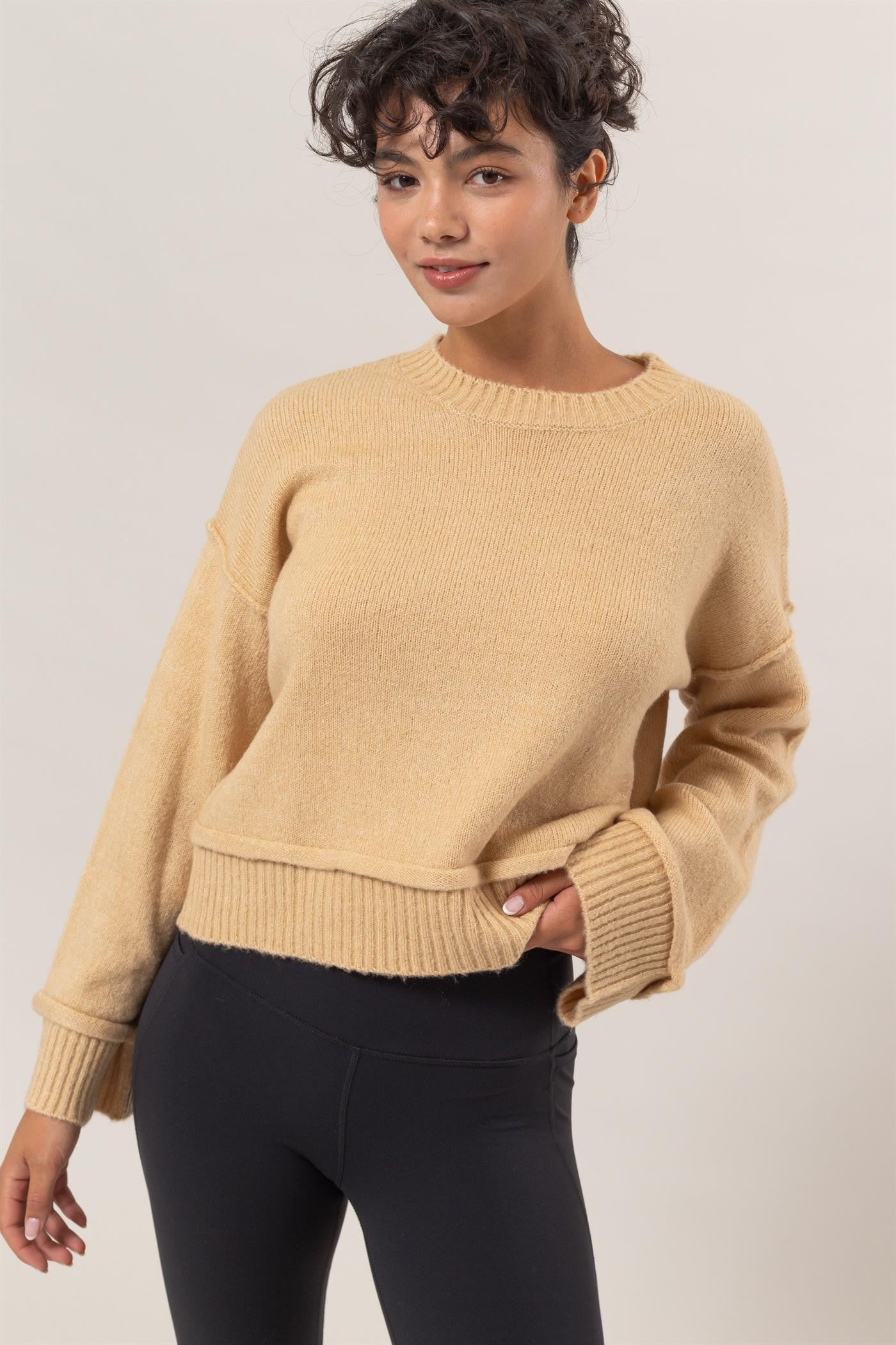 Beige ribbed sweater with crew neck, casual pose