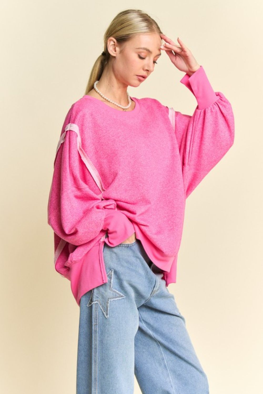 Pink high-low knit top with lantern sleeves, side view