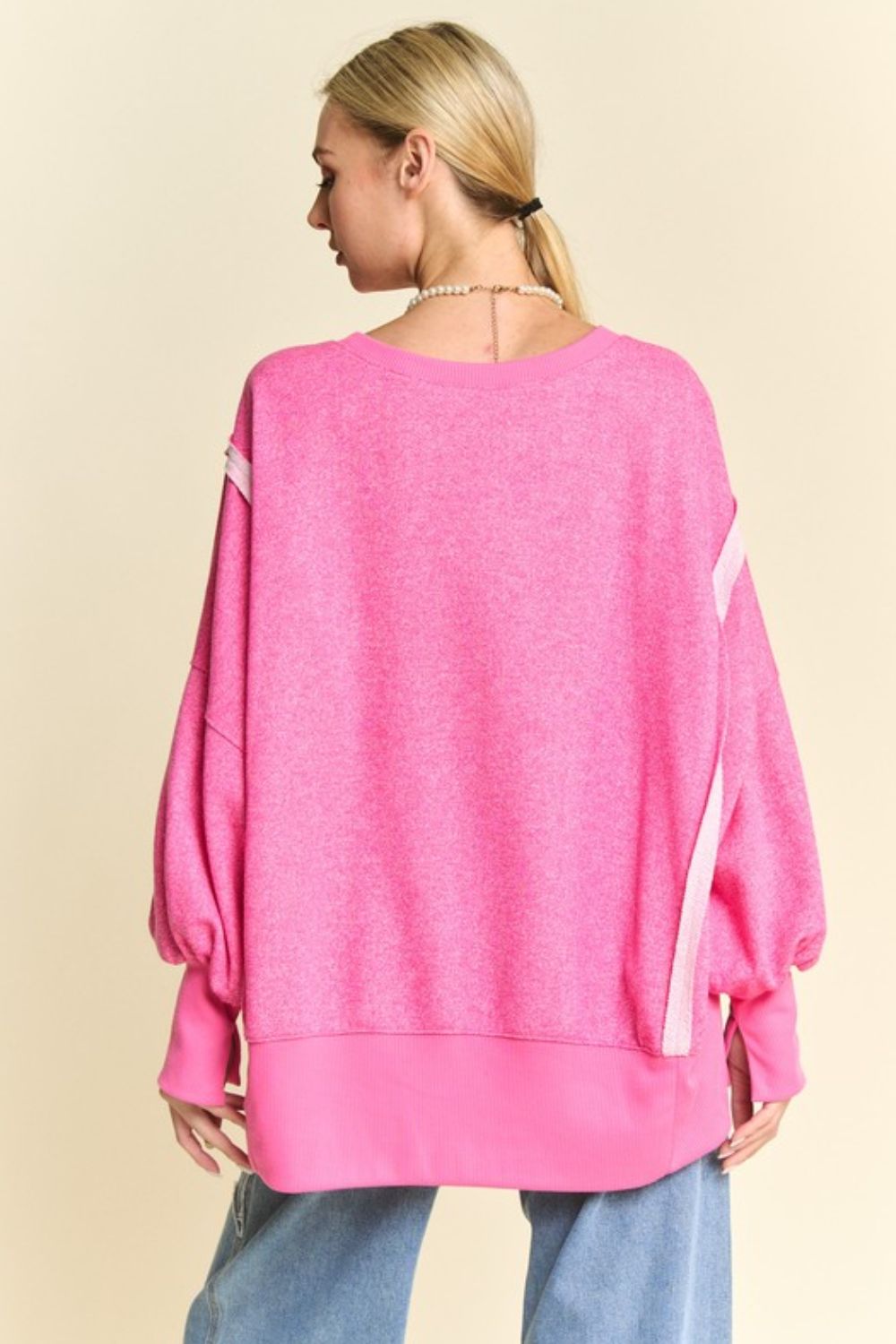 Pink high-low knit top with lantern sleeves, back view