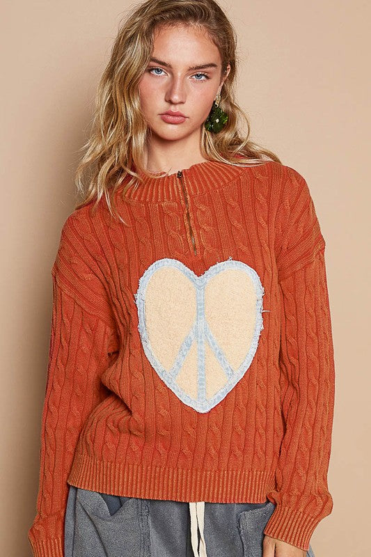 Orange cable-knit sweater with heart peace patch, front view