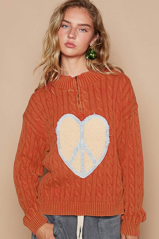 Front view of orange sweater with heart peace patch