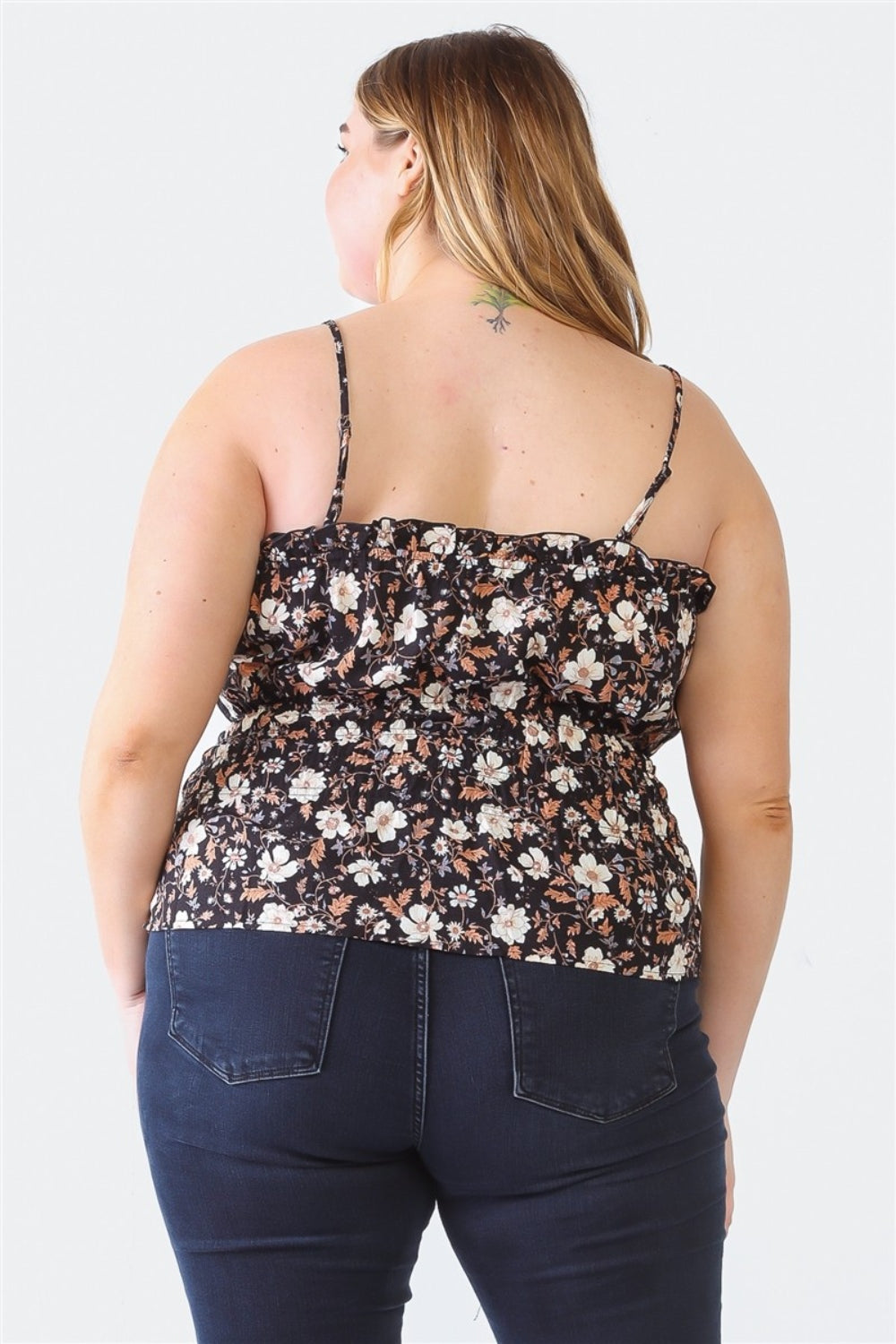 A person with long hair is wearing a black floral sleeveless top and dark jeans, standing with their back to the camera, showcasing a stylish Plus Size Cami | Zenobia Frill Floral Square Neck.