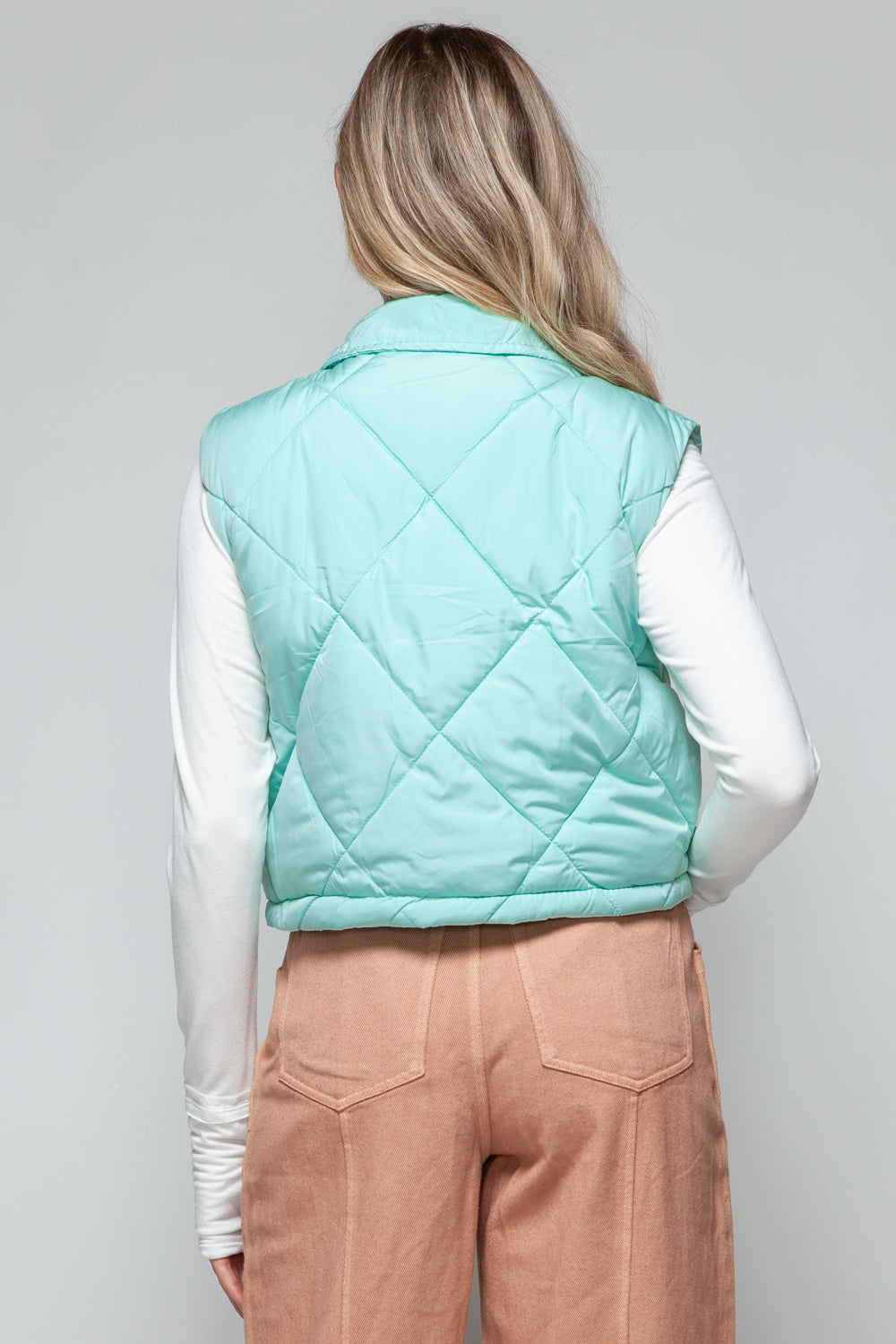 Back view of turquoise quilted crop vest